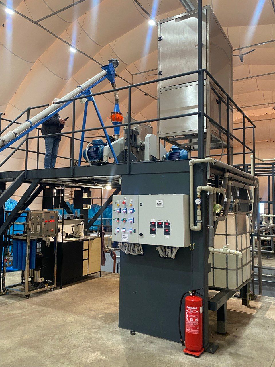 Production equipment with control panels, pipework and an operating platform